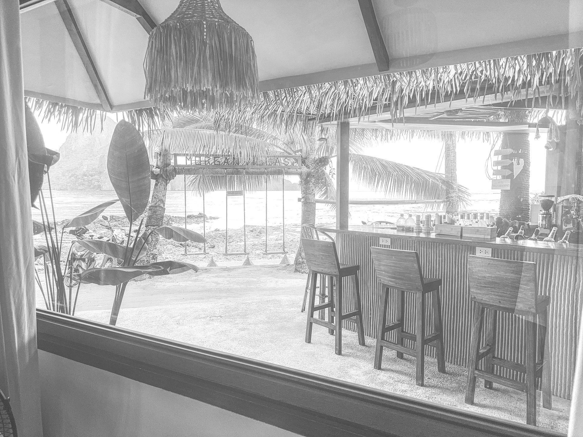 A black and white photo of a restaurant with tables and chairs