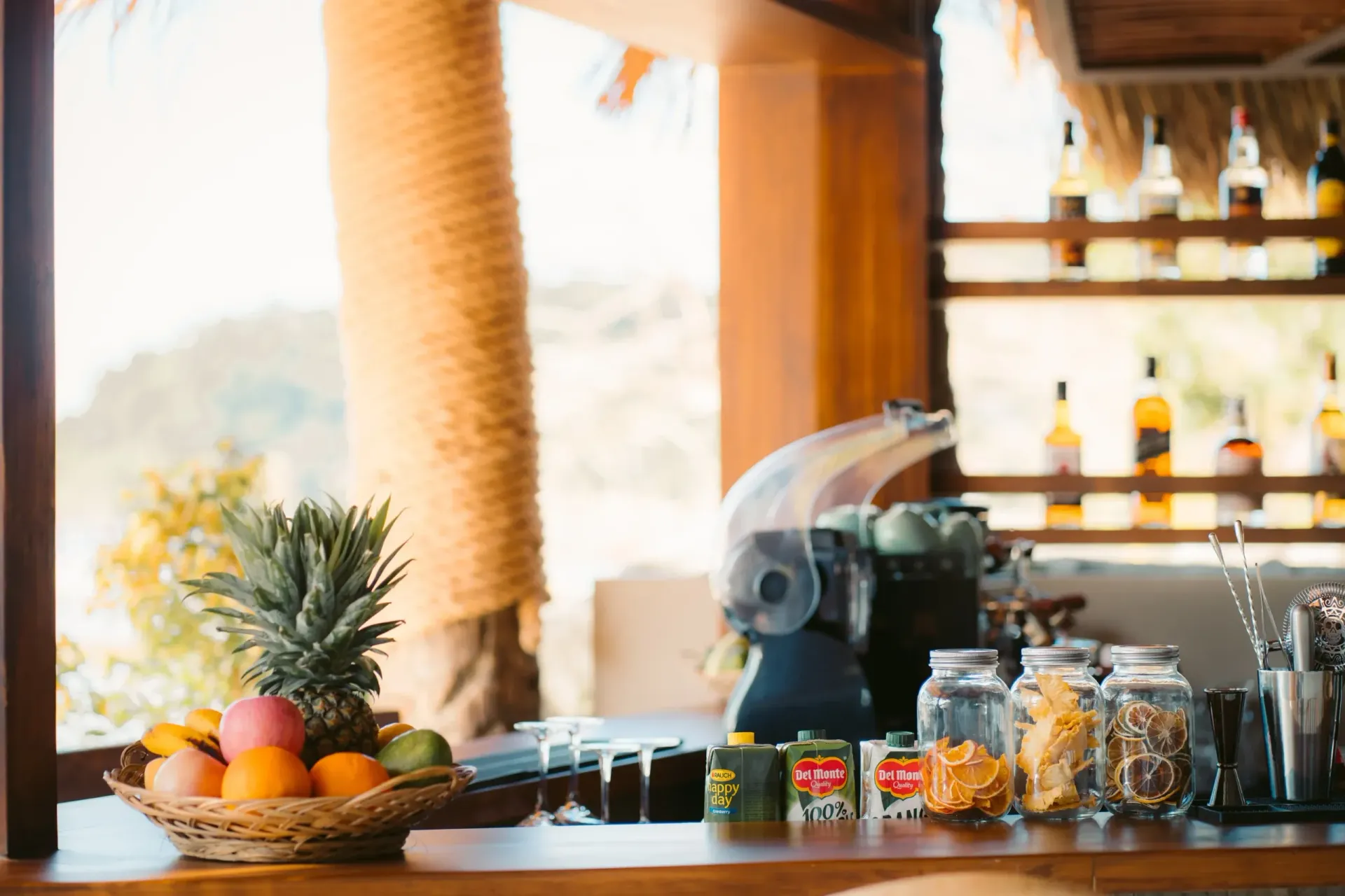 A bar with a pineapple and a basket of fruit on it.