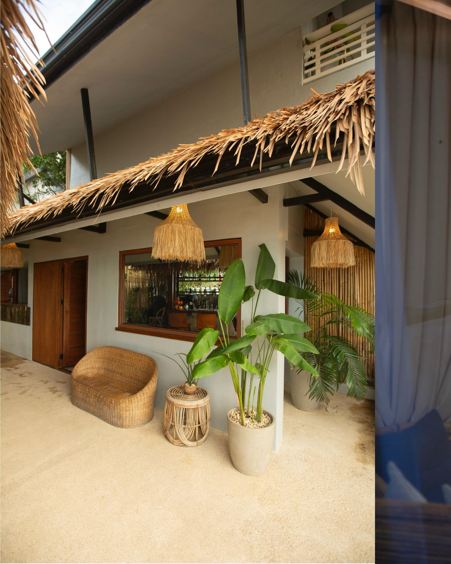 A house with a thatched roof and potted plants