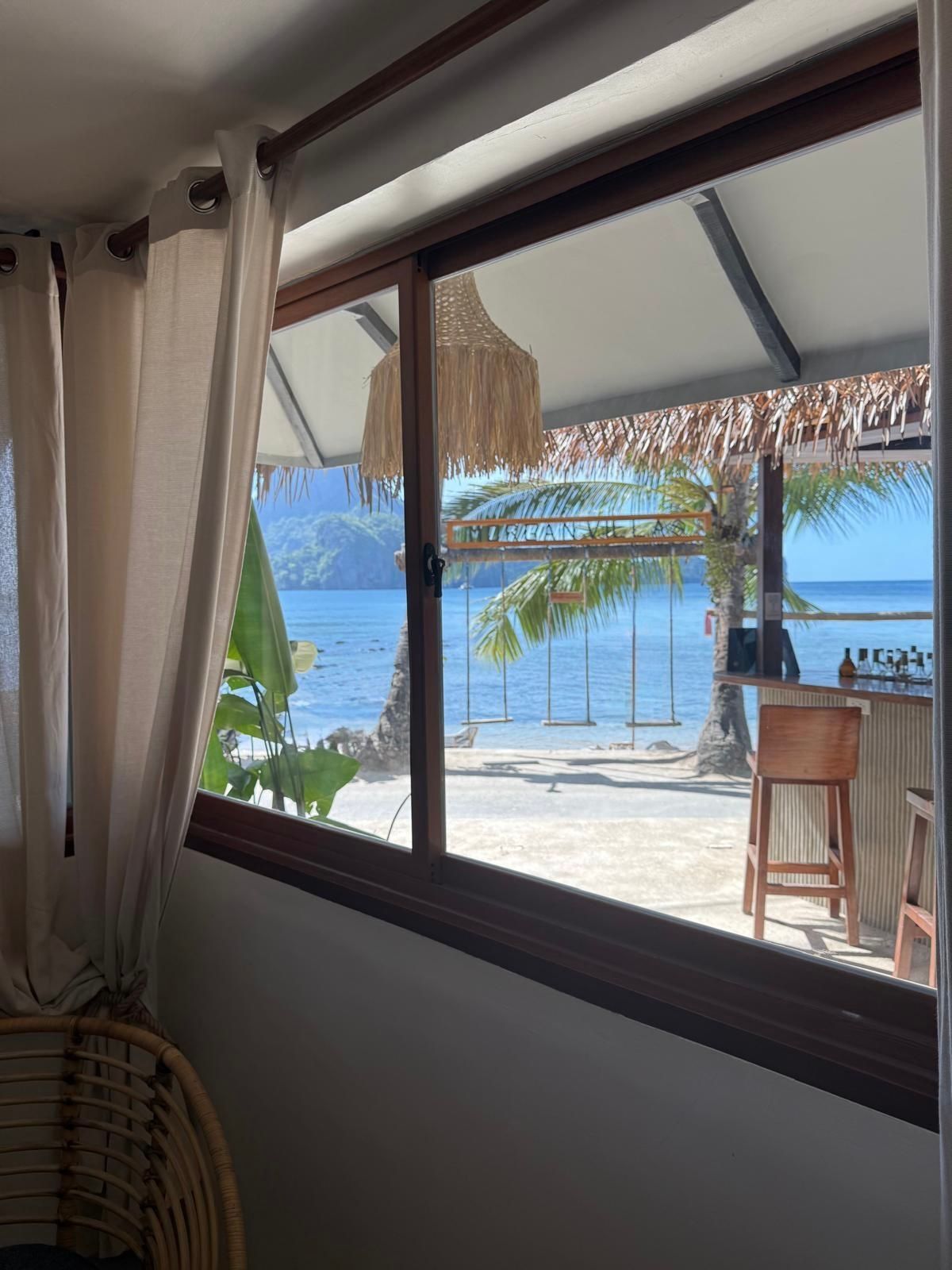 Room 1 . A room with a view of the ocean through a window.