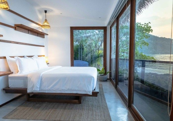 A bedroom with a large bed and lots of windows.