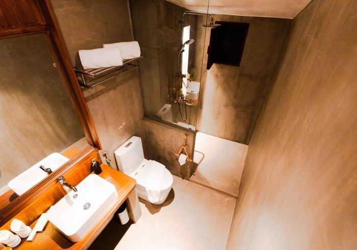 A bathroom with a toilet , sink , mirror and shower.