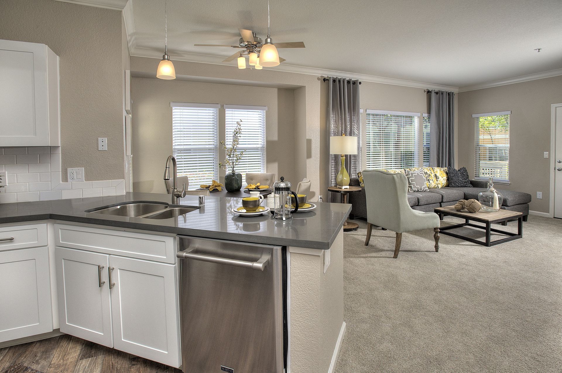 Open-concept kitchen with island and living room in a modern apartment.