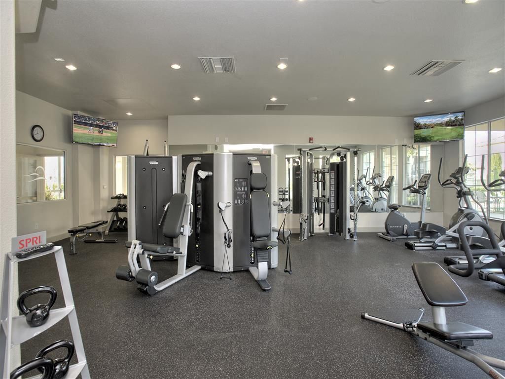 Indoor community gym with cardio equipment and weight machines.