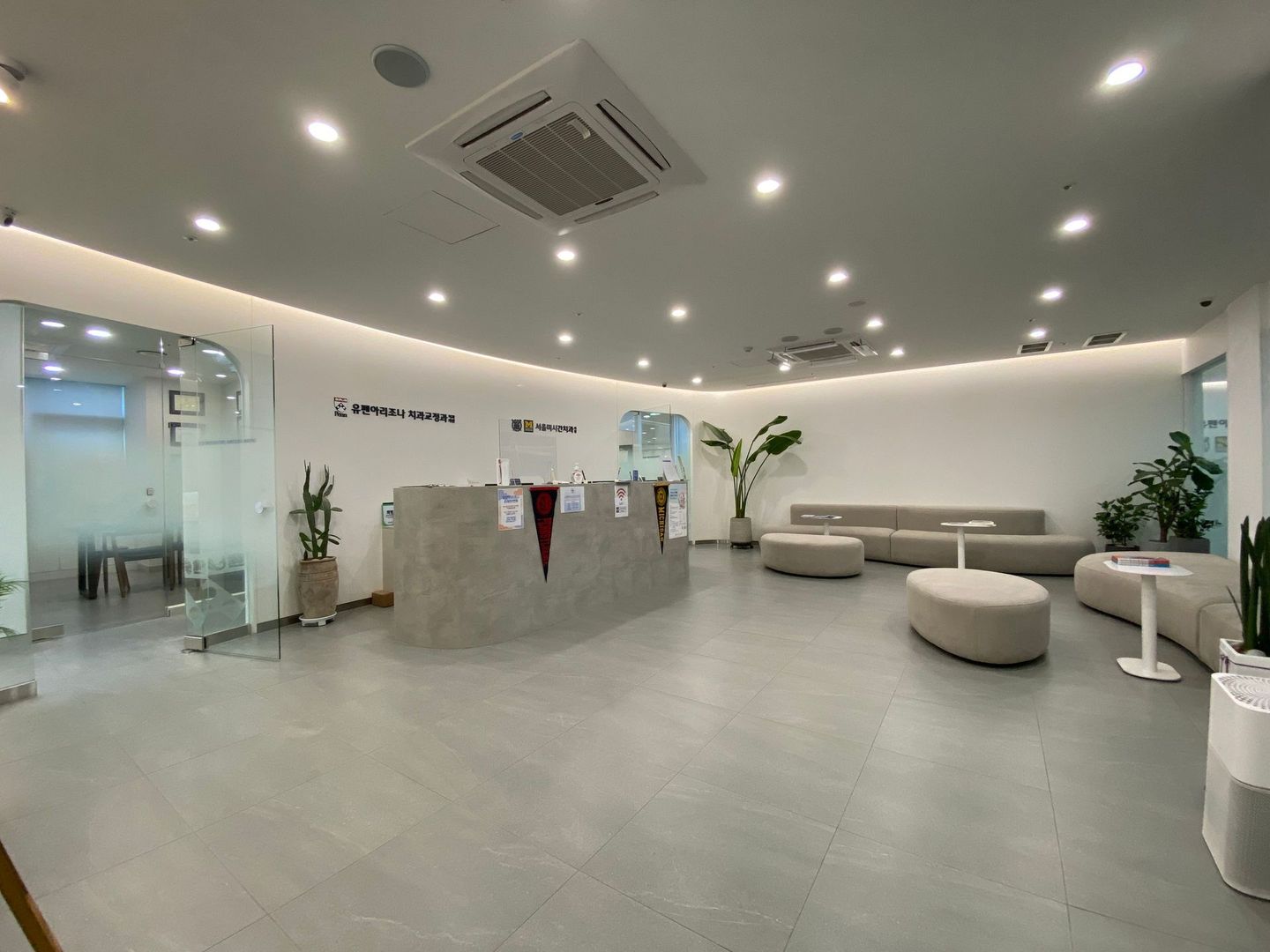 A large waiting room with a reception desk and a couch.