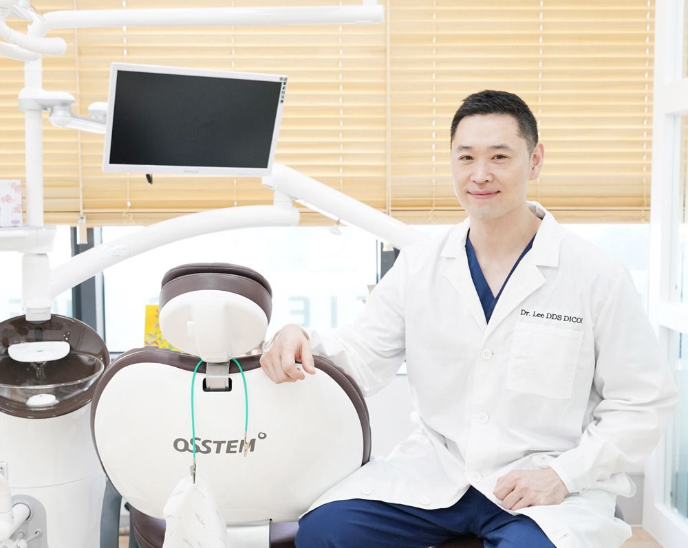 A dentist is sitting in a dental chair in a dental office.