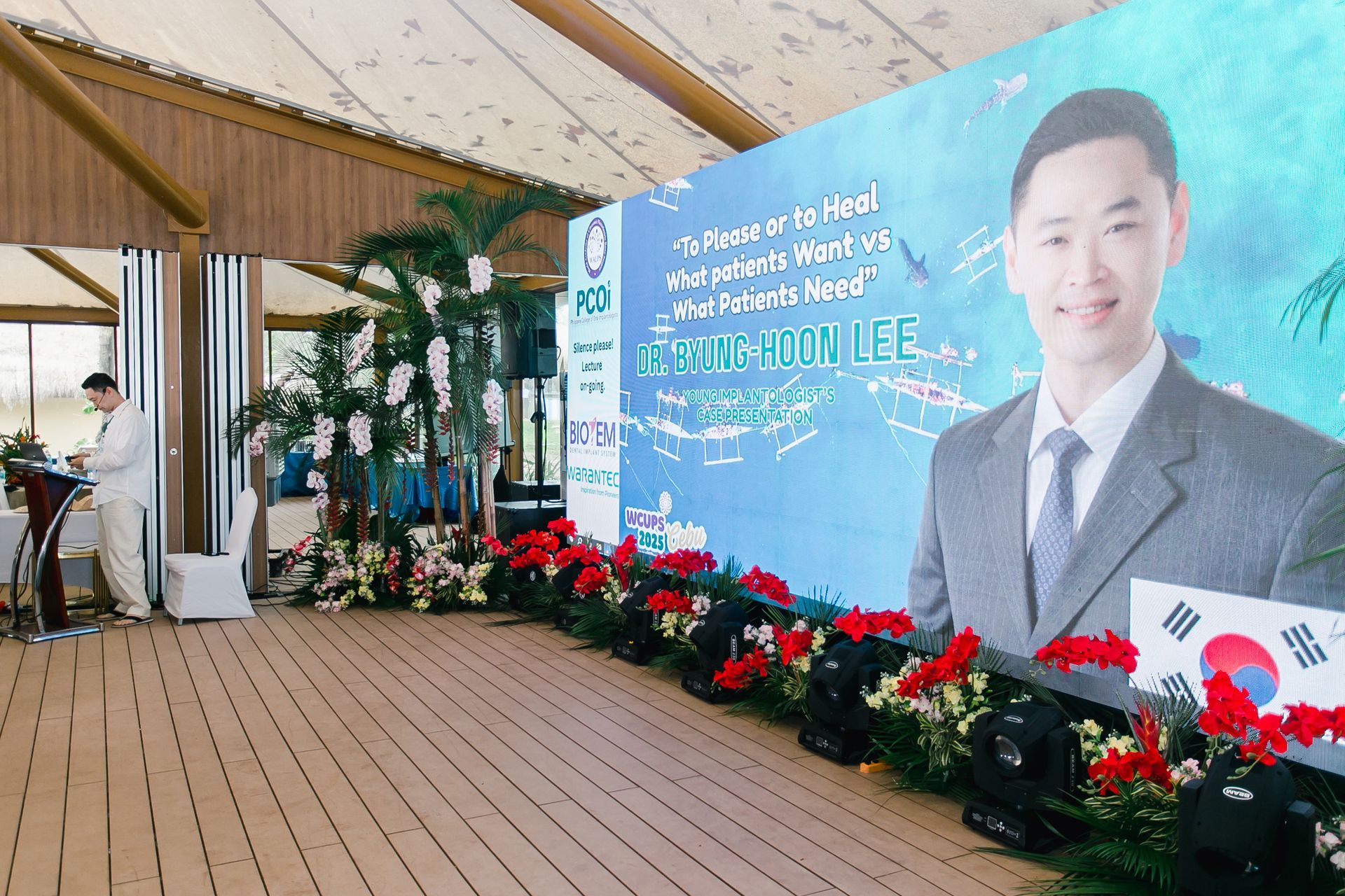 A long hallway with a white wall and a glass door