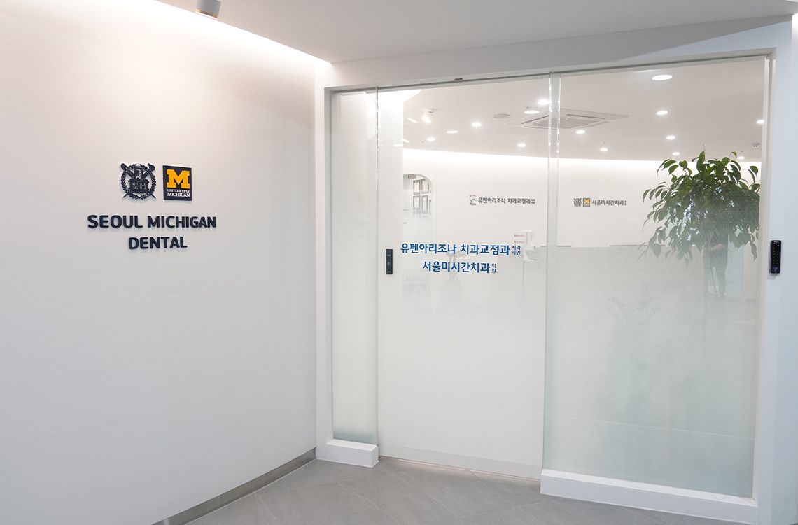 A dental office with a glass door and a sign on the wall.