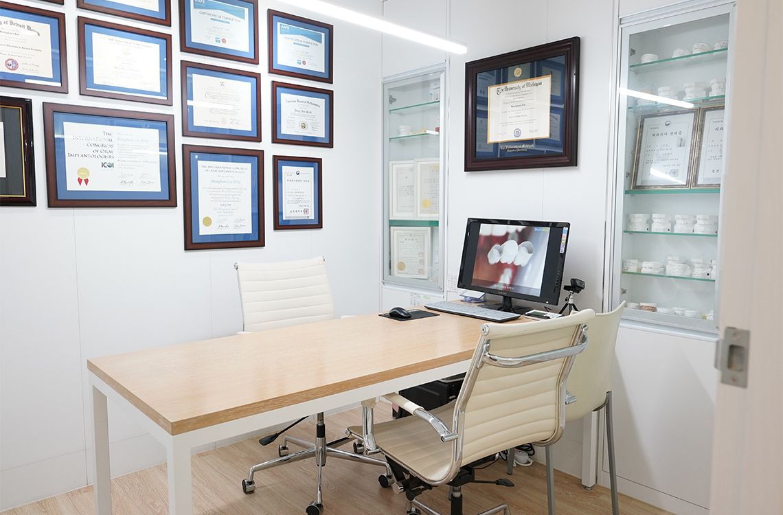 A conference room with a table and chairs and a computer.