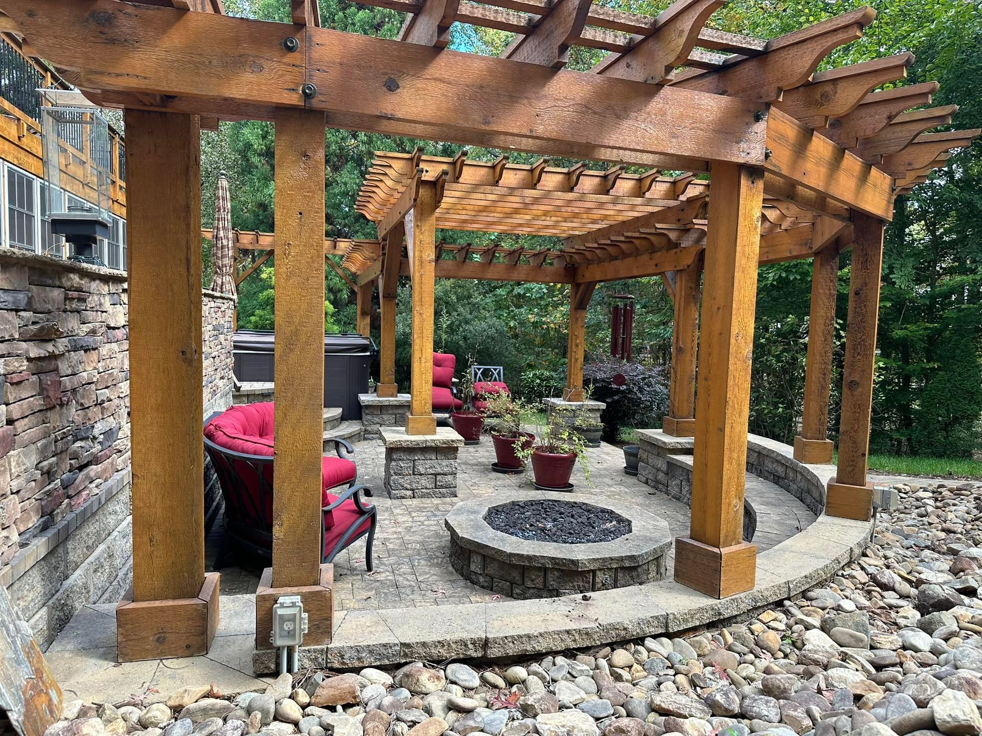 Outdoor patio with a pergola, fire pit, and seating.