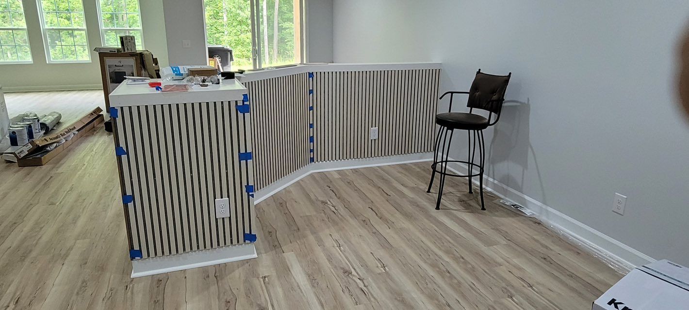 Interior with a bar-like structure, high chair, wood floors, and a railing with a striped design.