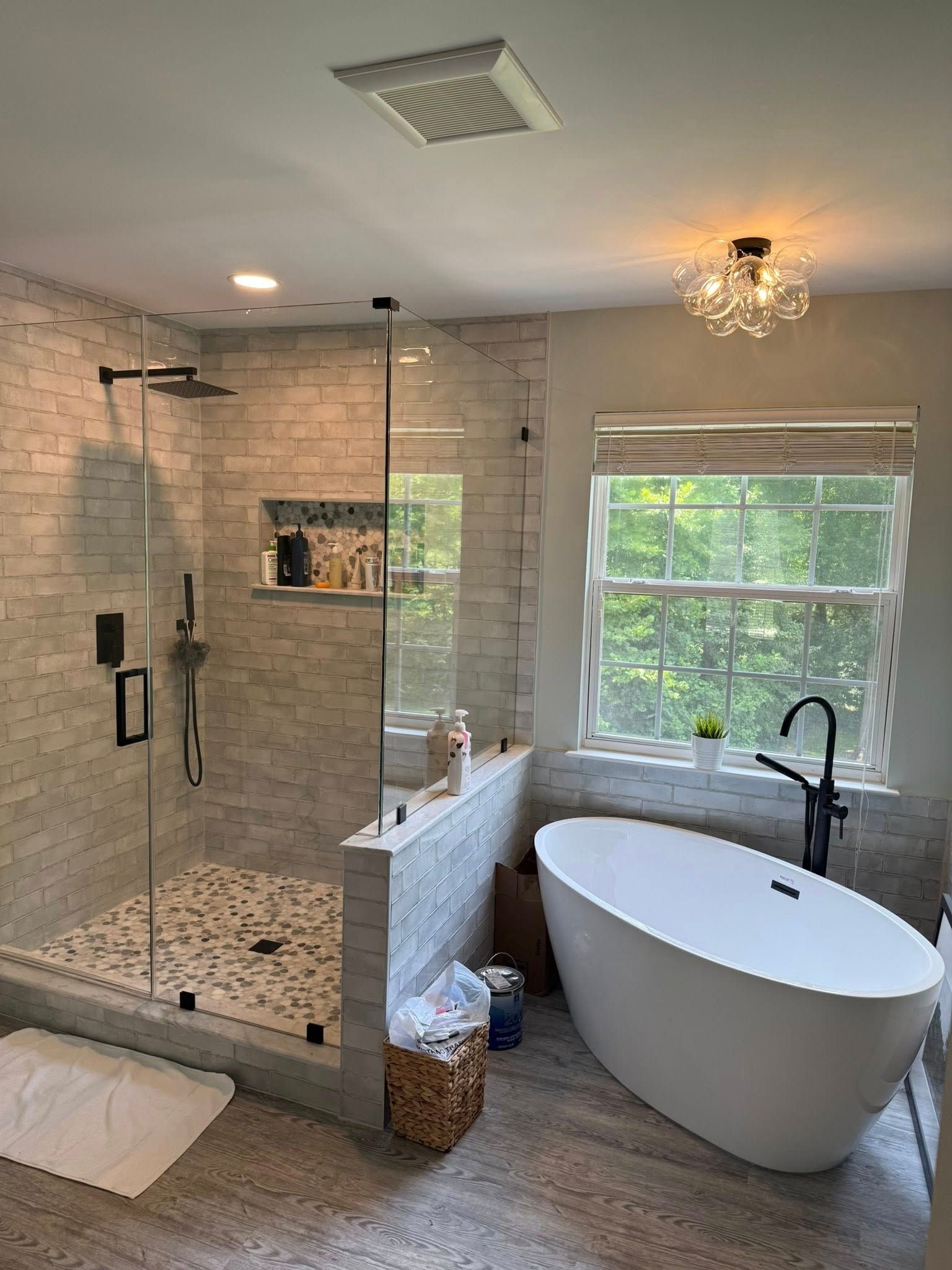 Modern bathroom with a glass shower, white soaking tub, and neutral color scheme.