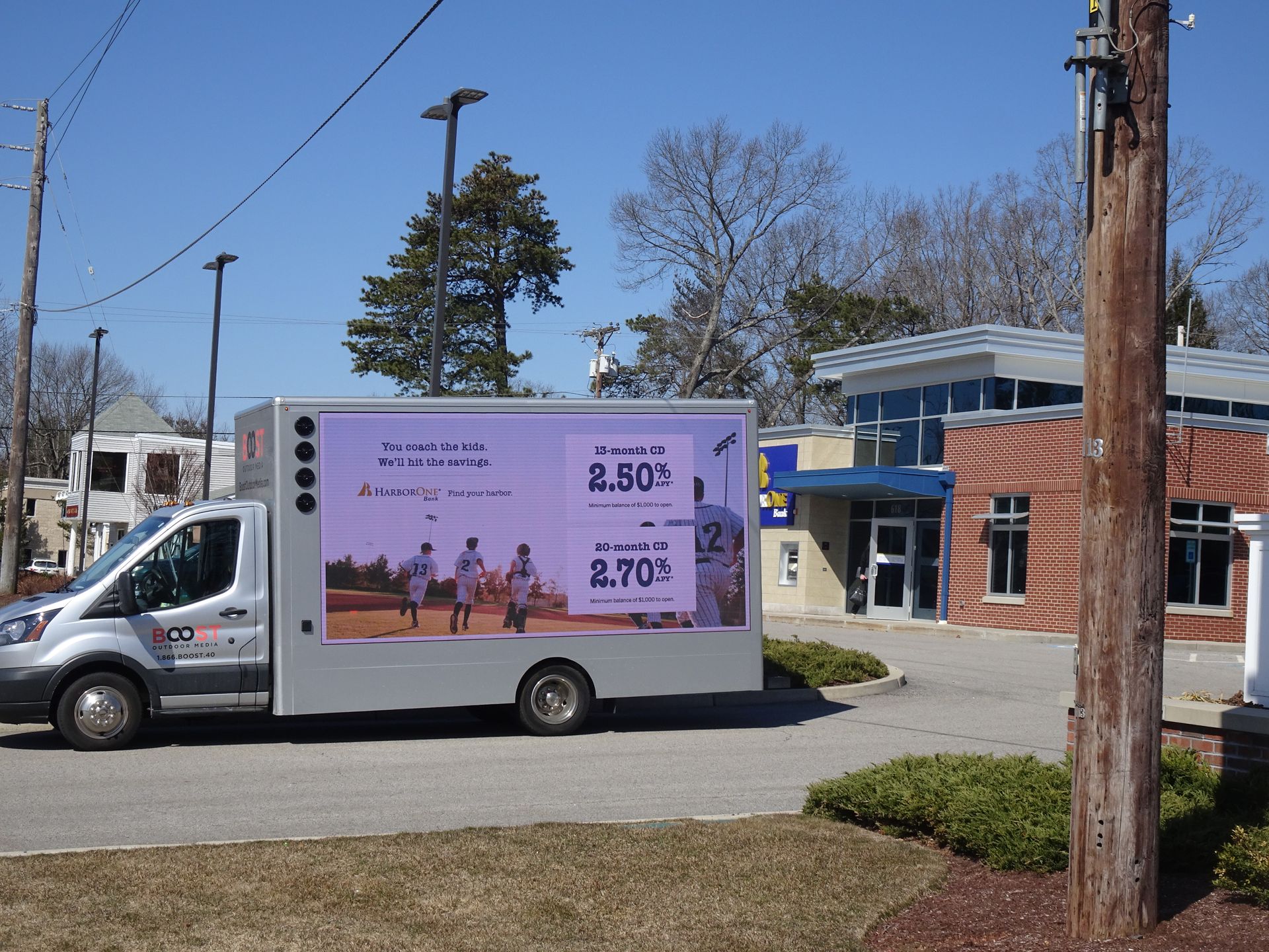 Mobile digital billboard displaying a vibrant bank advertisement on a busy city street and Innovative mobile billboard advertising various banking services, driving through an urban area