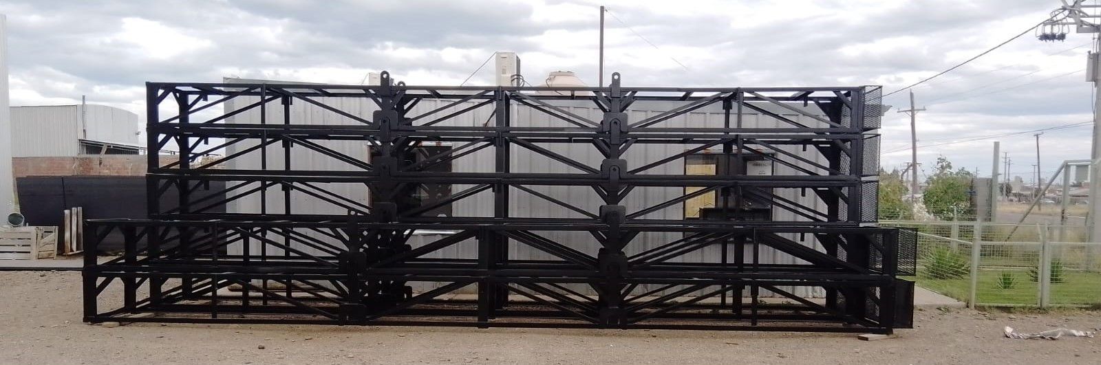 Una gran estructura rectangular de acero negro, al aire libre. El cielo está nublado.