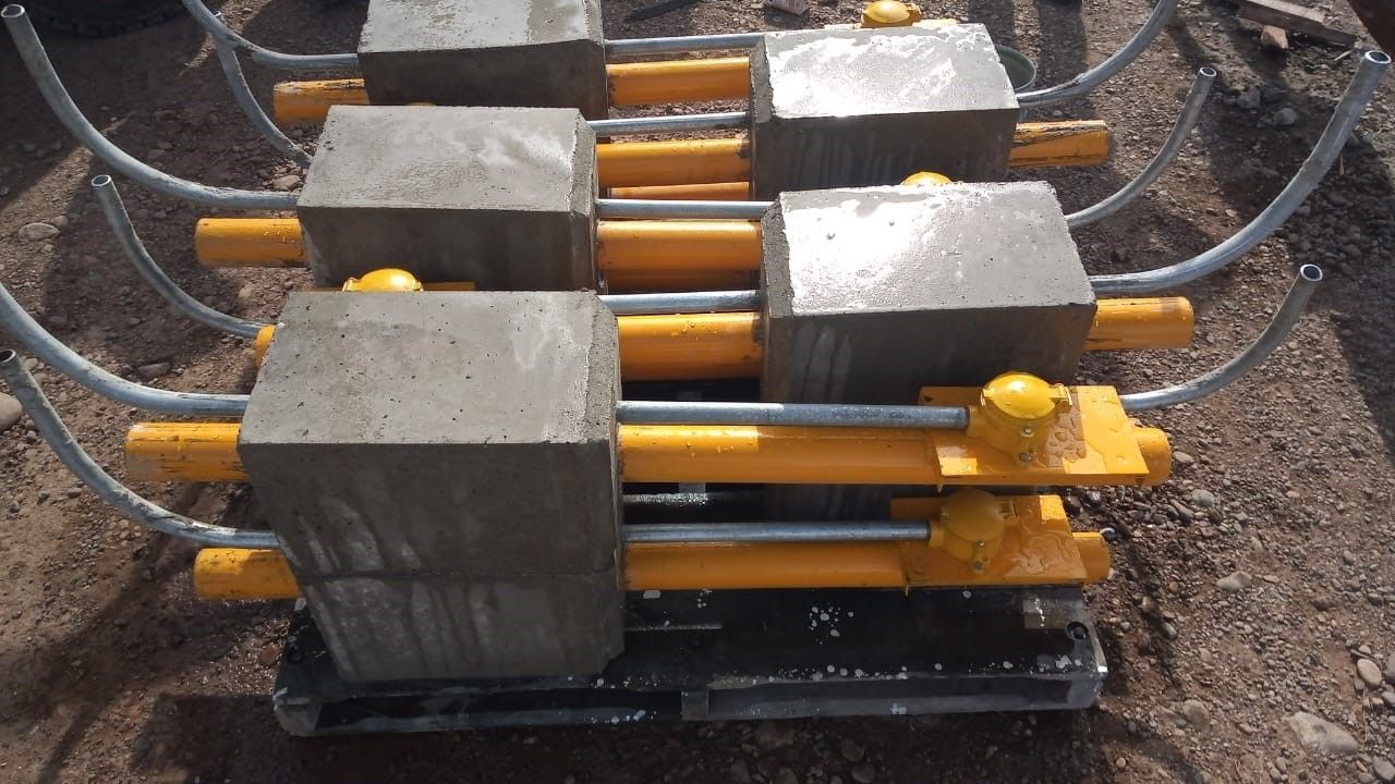 Seis bloques de hormigón con componentes metálicos de color amarillo y gris.