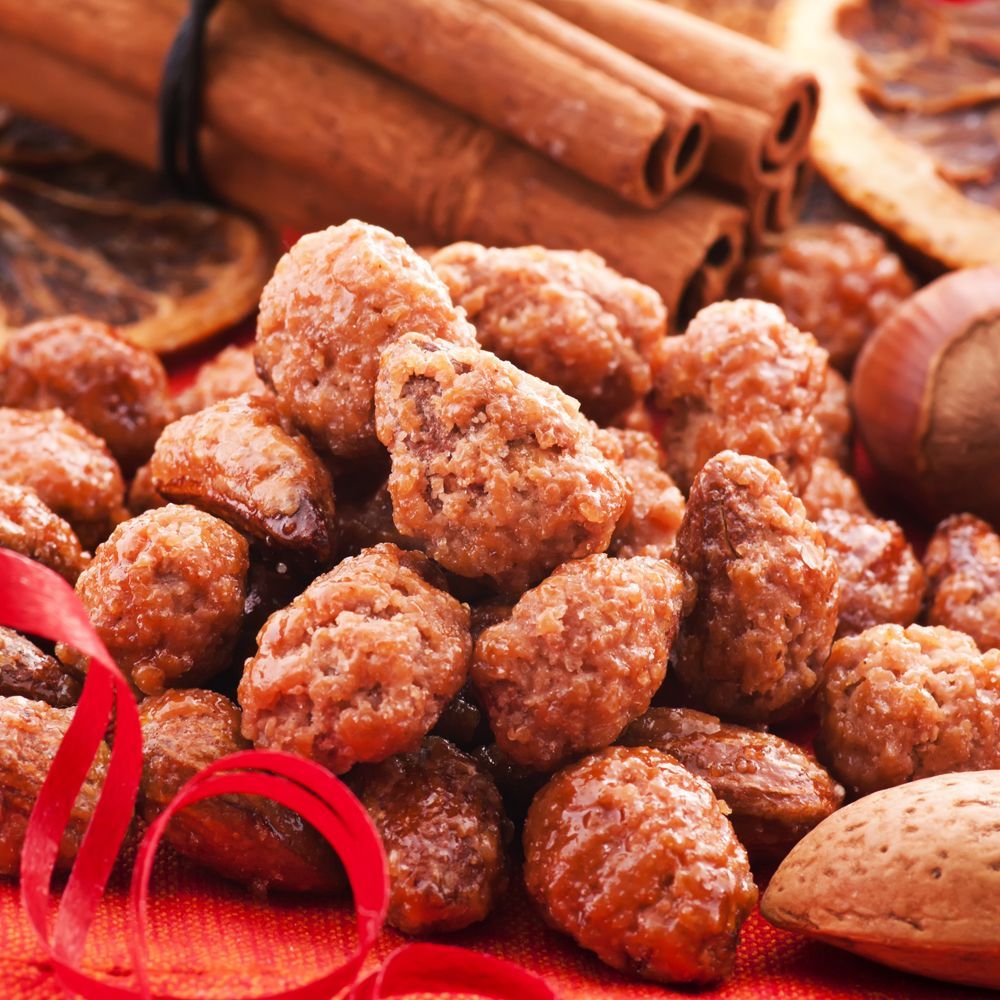 A pile of nuts with cinnamon sticks and a red ribbon