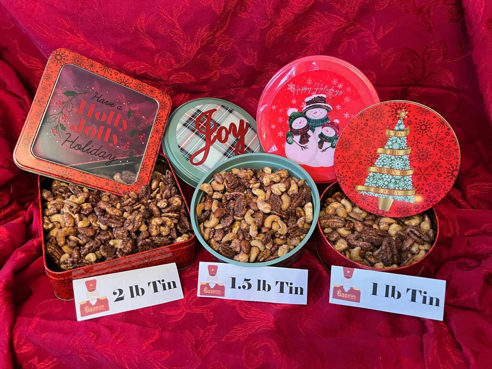 A heart shaped tin filled with nuts that says filled with love