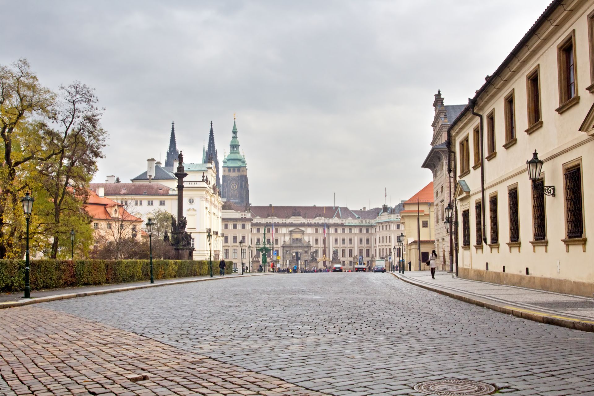 A cobblestone street with a castle in the background