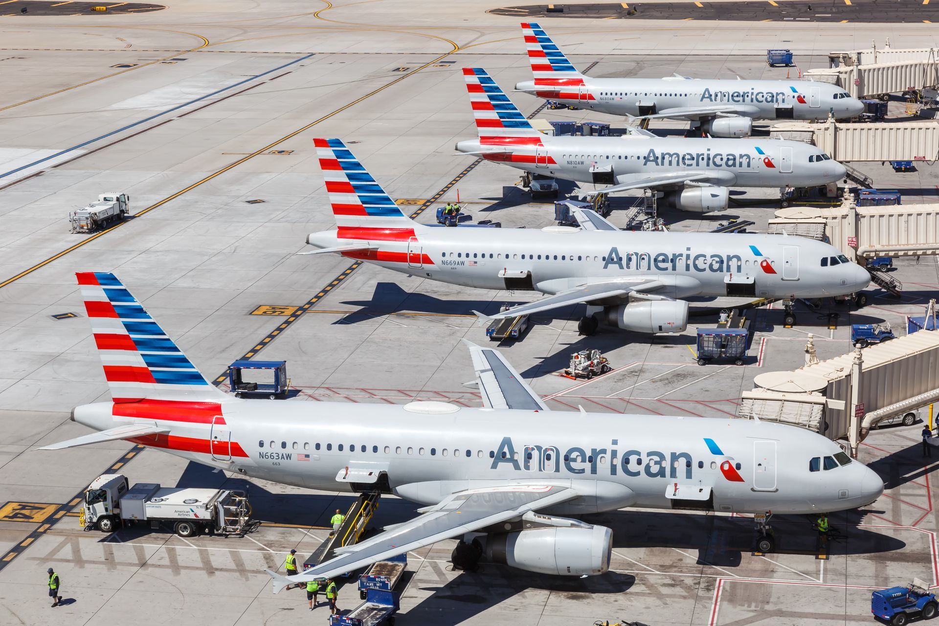 A row of american airlines planes are parked at an airport.