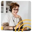 a woman wearing headphones and glasses is sitting in front of a laptop computer .