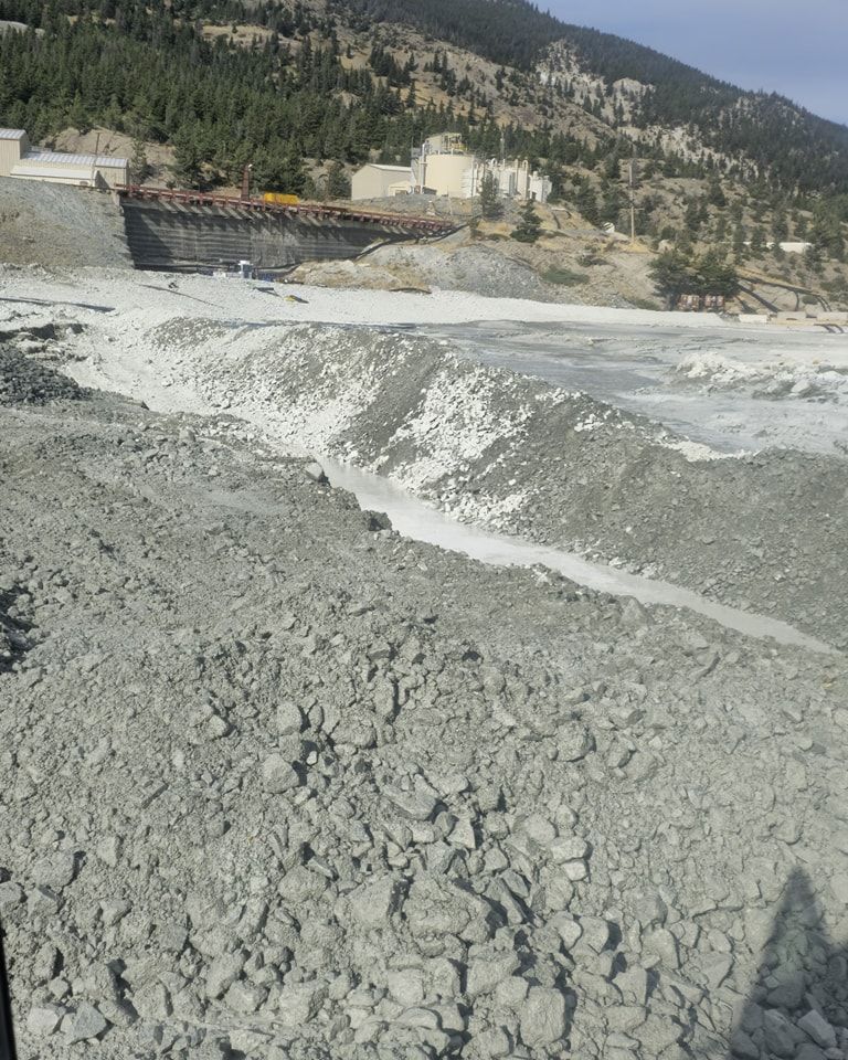 A river flowing through a rocky landscape with mountains in the background