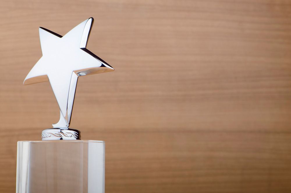 A Trophy with A Star on Top of It on A Wooden Table — Brookes Engraving & Signs in Unanderra, NSW