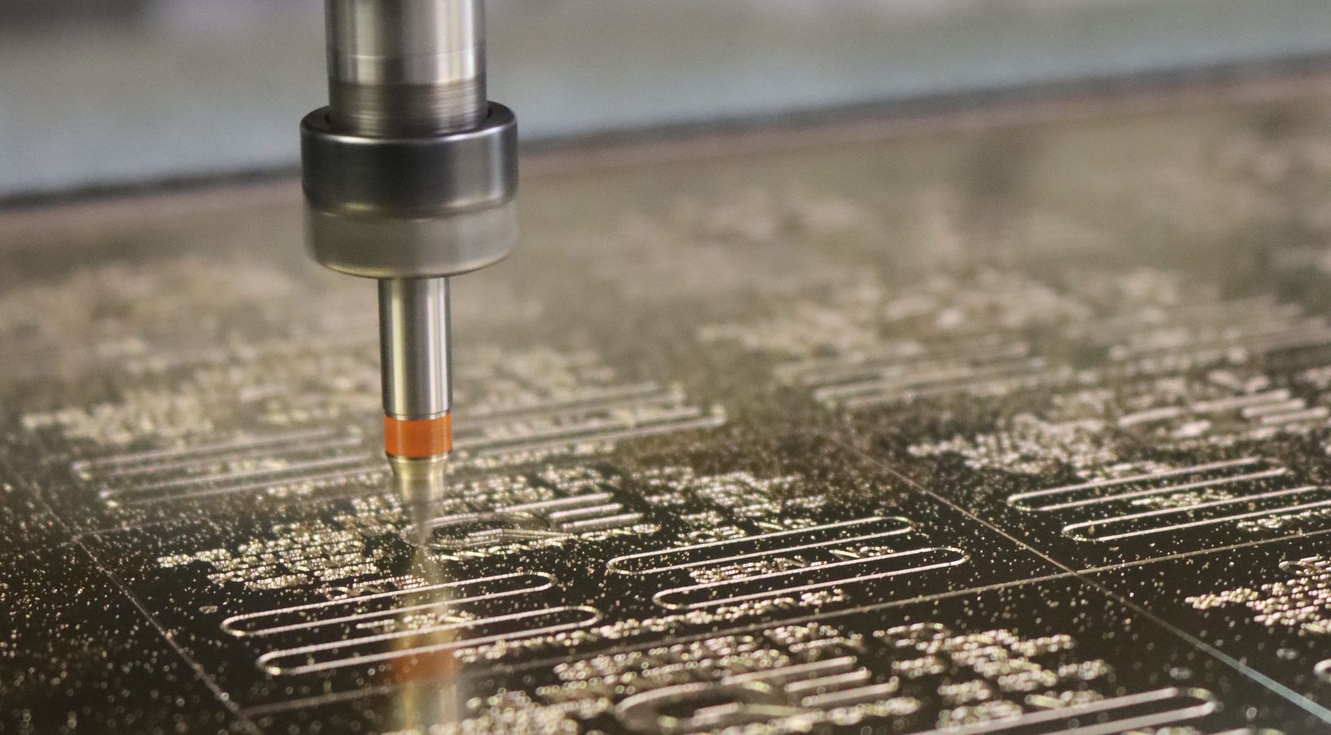 A machine is cutting a piece of metal on a table. — Brookes Engraving & Signs in Woonona, NSW