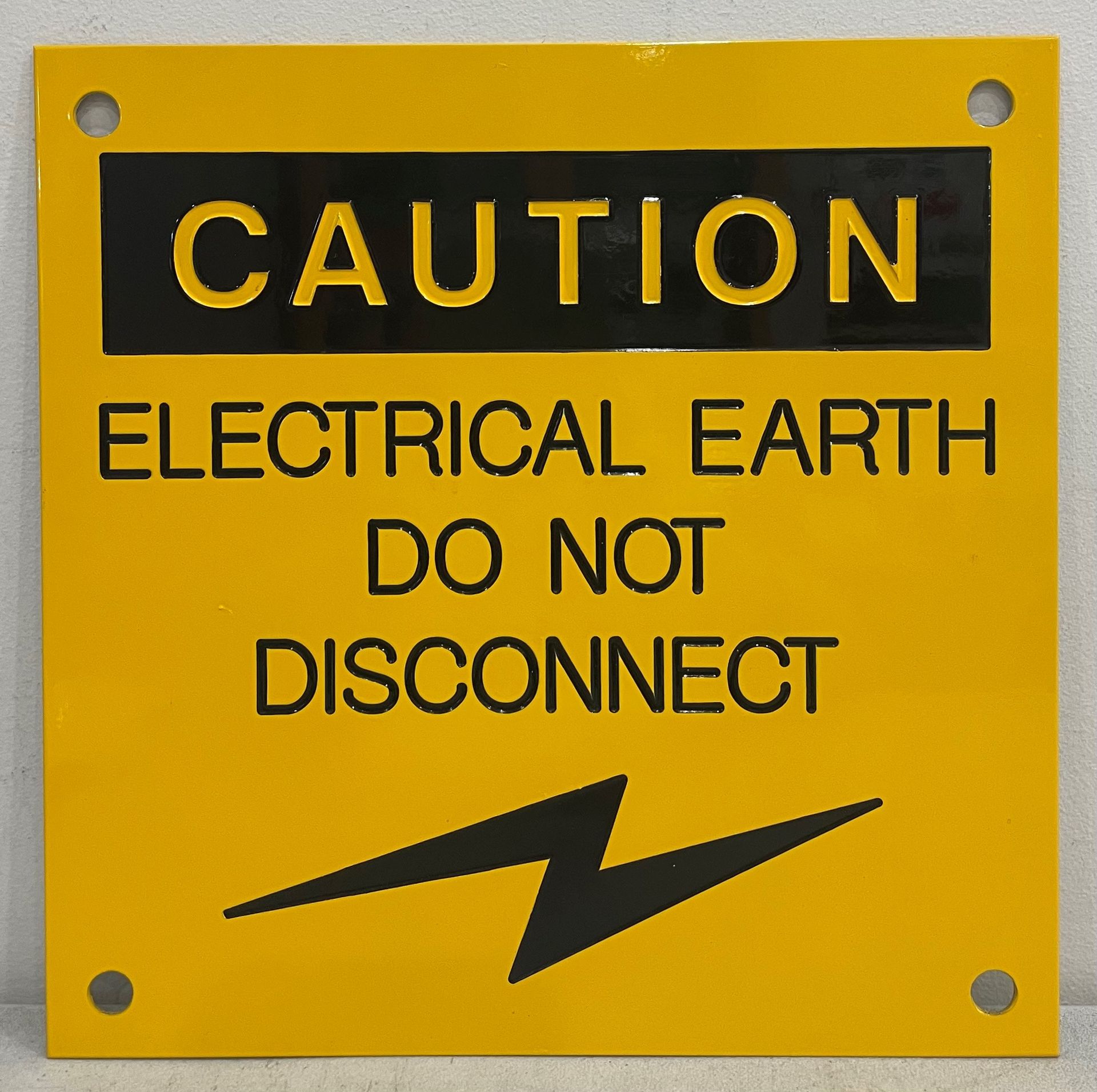 A yellow sign that says caution electrical earth do not disconnect — Brookes Engraving & Signs in Woonona, NSW