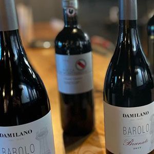 Three wine bottles on a wooden surface; one labeled 