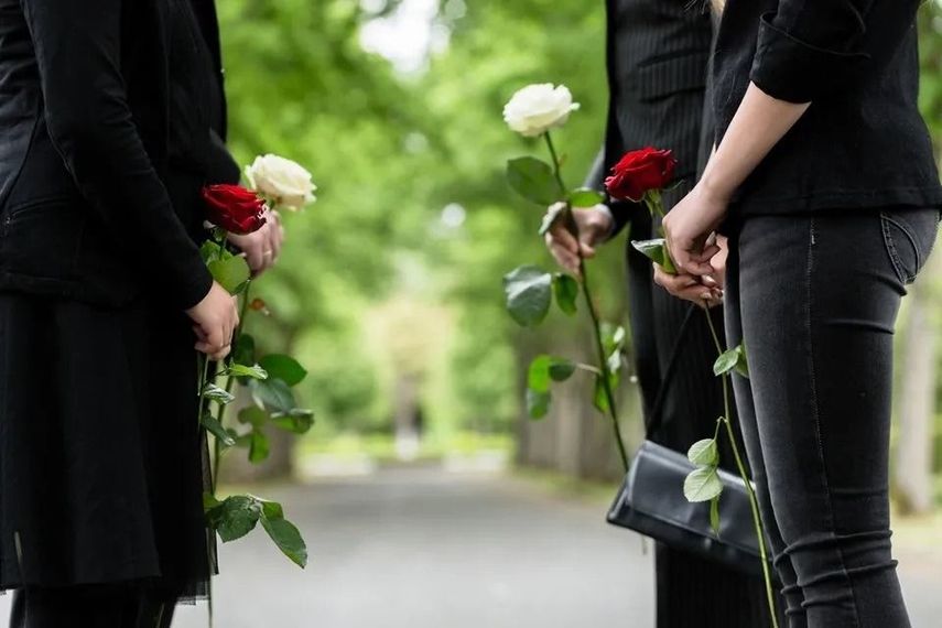 Persone con fiori a un funerale