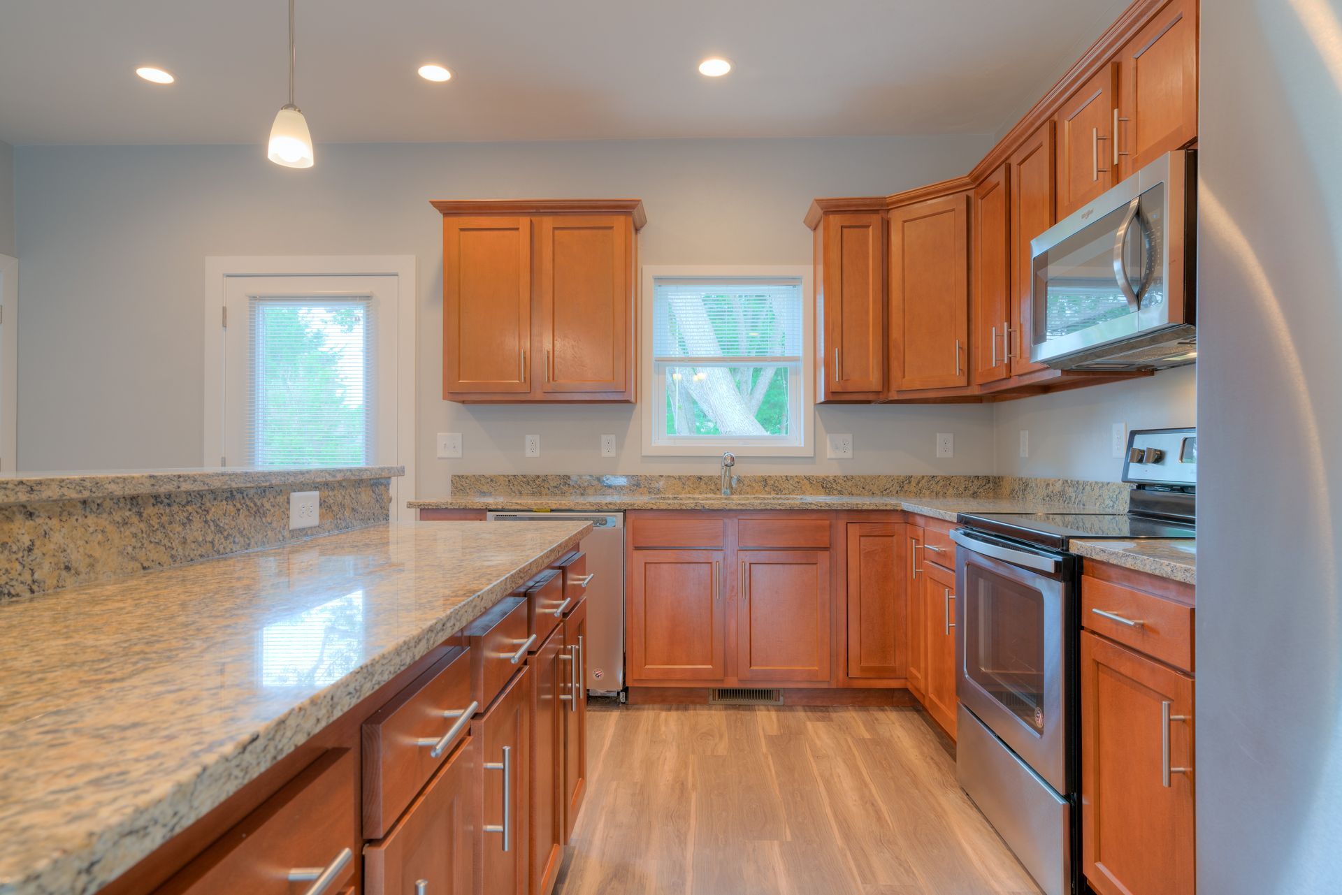 Kitchen with brown cabinets, granite countertops, and stainless steel appliances.