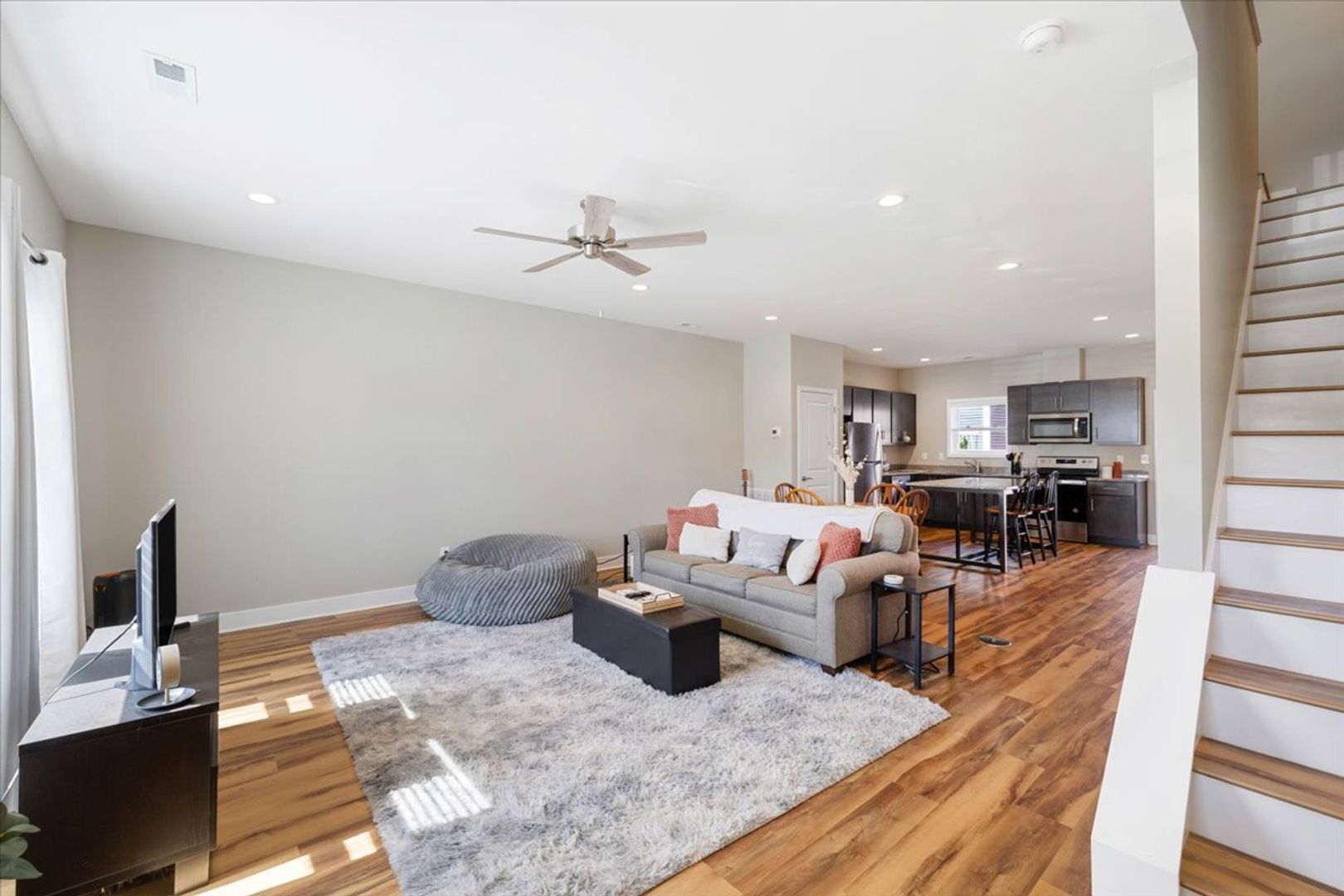 Modern open-concept living space with gray walls, kitchen, and living room furniture.