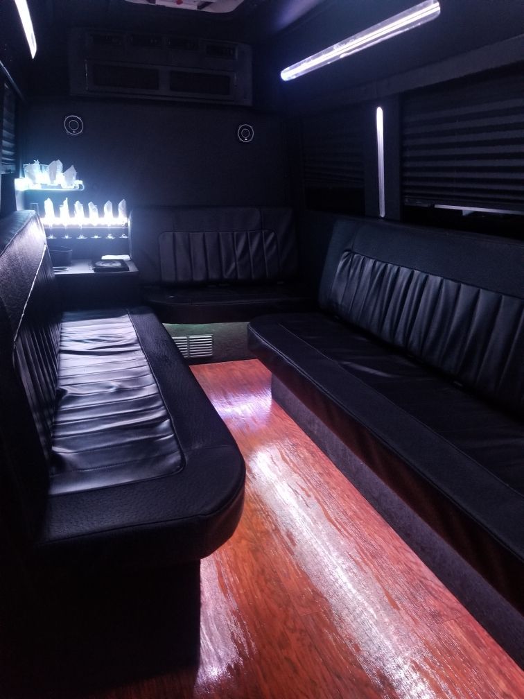 A black limousine is parked next to a white truck
