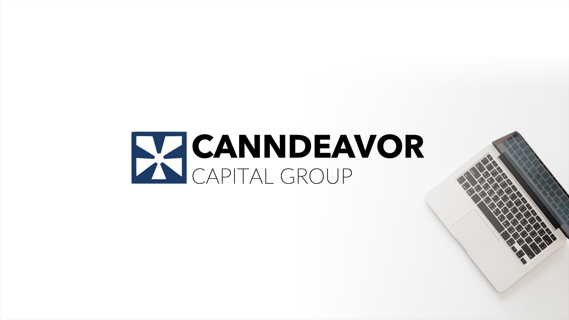 a laptop computer is sitting on a white table next to a canndeavor capital group logo .