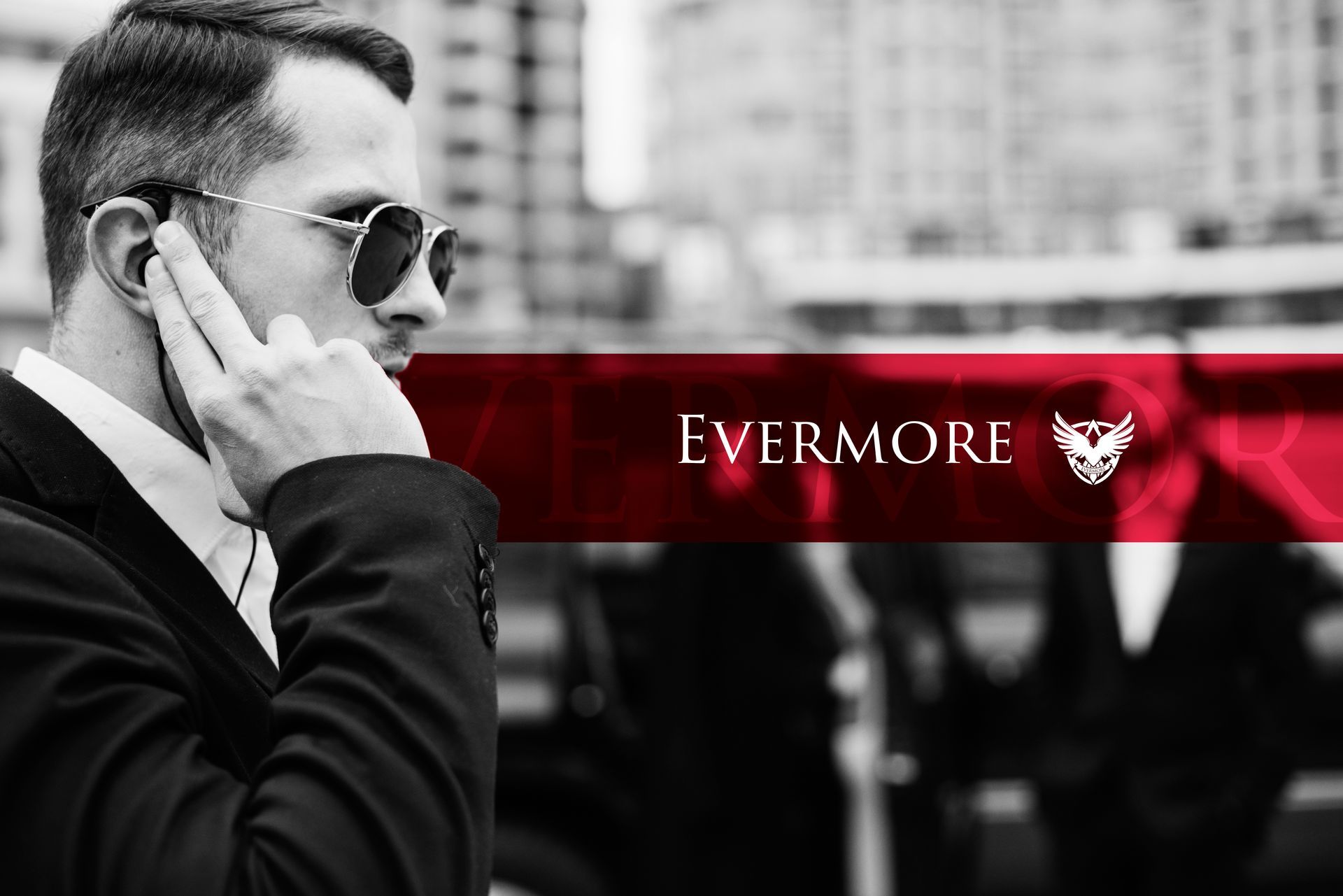 Man in suit with earpiece, sunglasses; red accent and text 