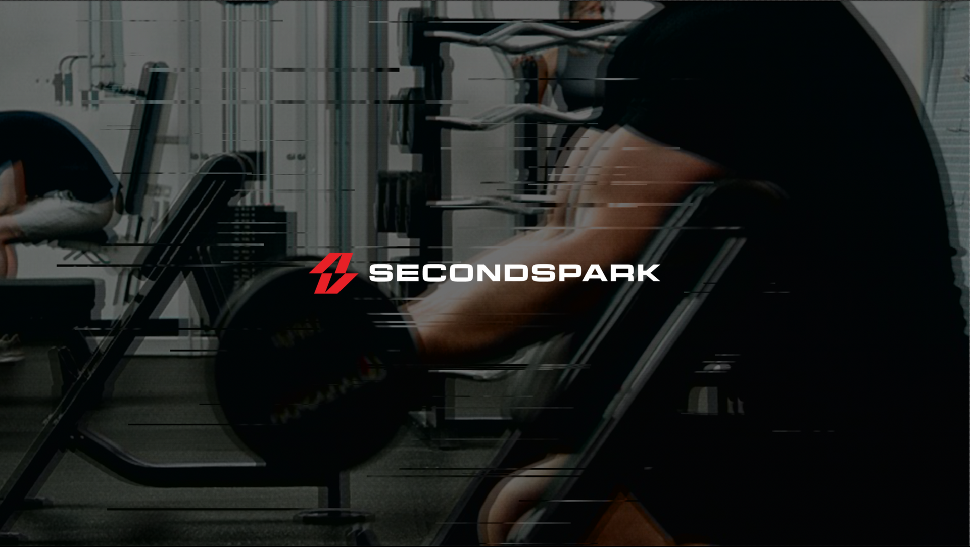Person working out at a gym using a seated barbell curl machine; secondsspark logo visible.