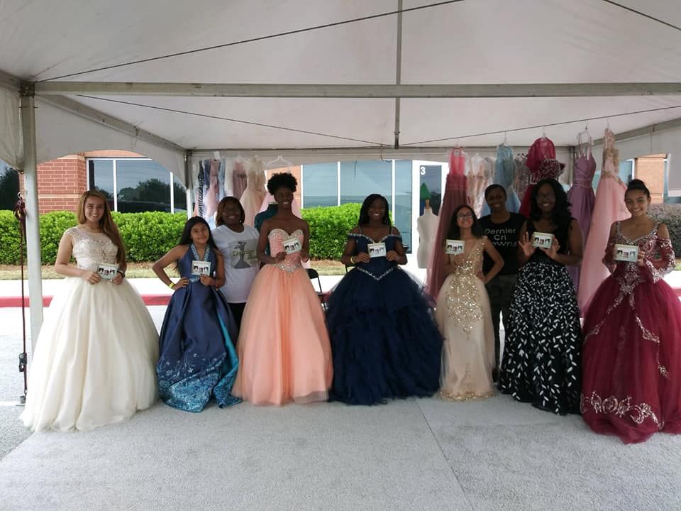 Bride and her mother walk down aisle. The bride in a white dress, the mother in emerald green. Outdoors.