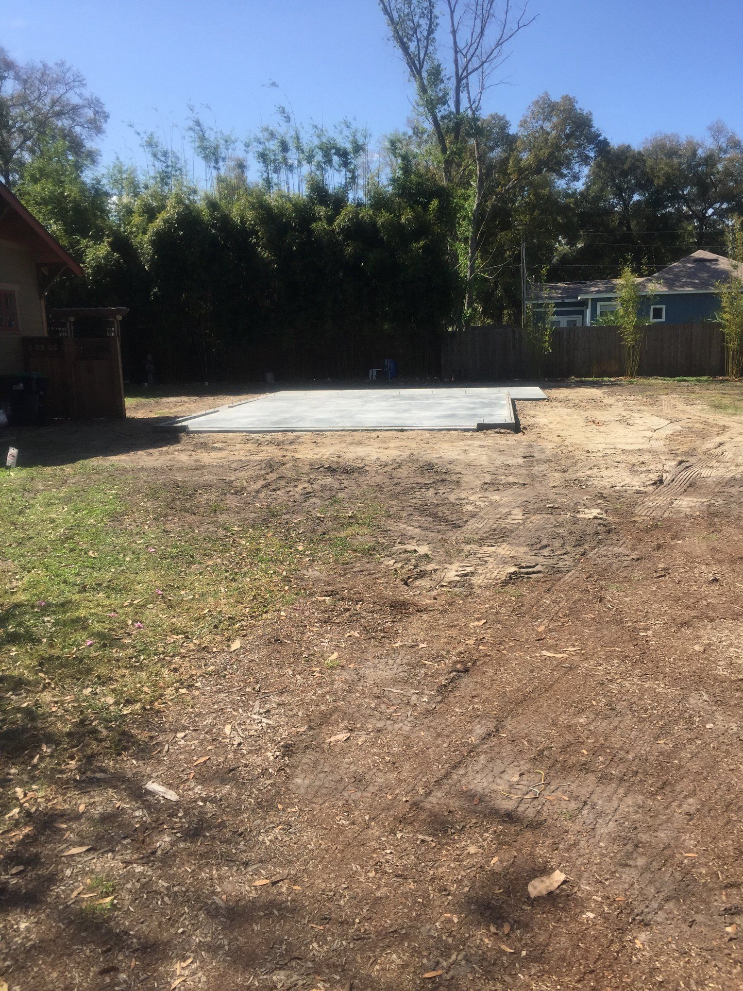 A dirt field with a concrete slab in the middle of it.