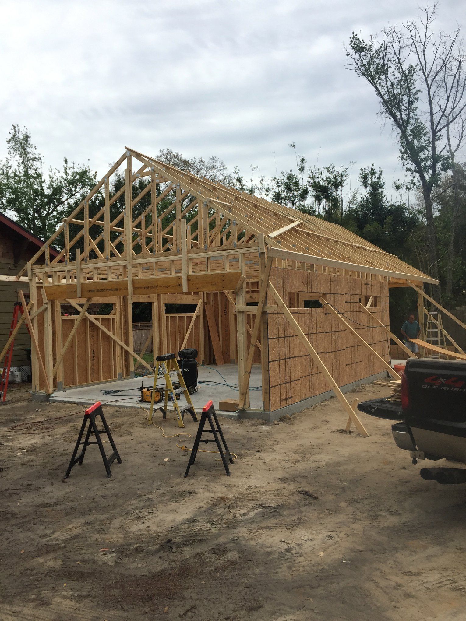 A truck is parked in front of a house under construction.