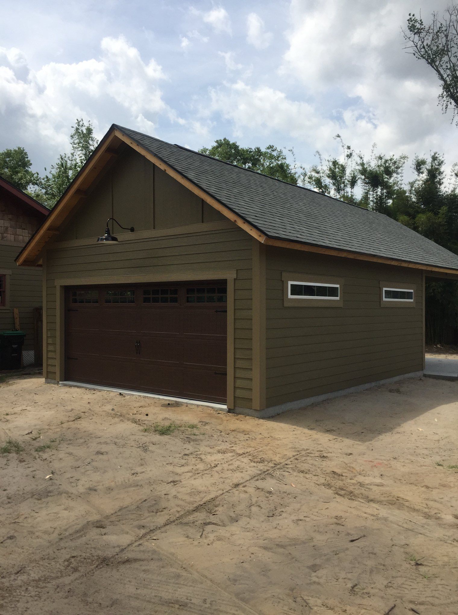 A garage with a brown door and a gray roof