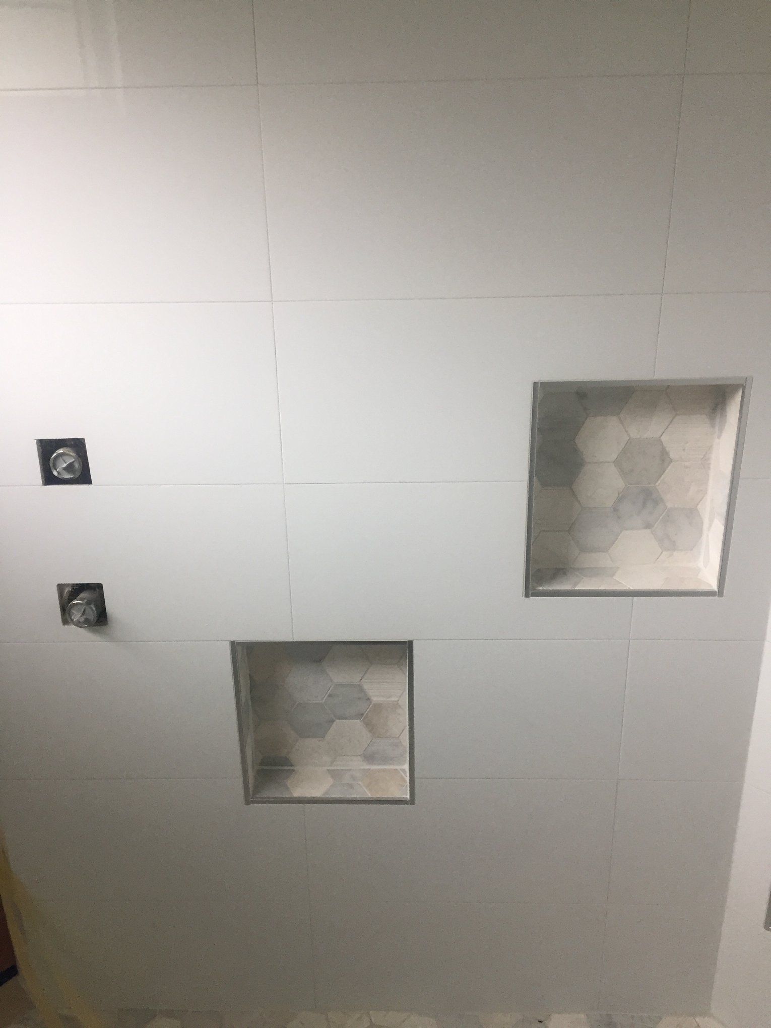 There are three square niches in the ceiling of a bathroom.
