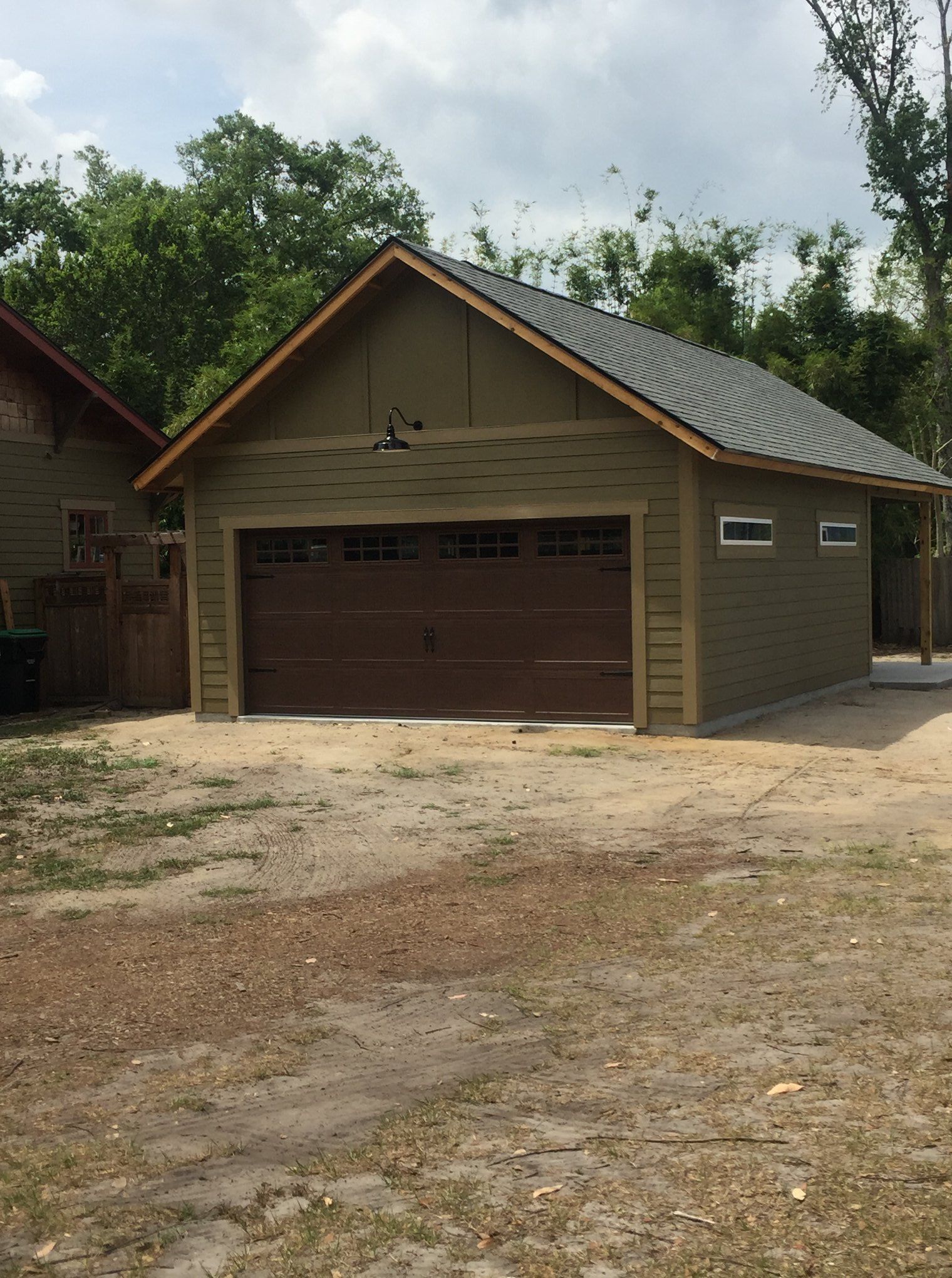 A garage with a brown door and a gray roof