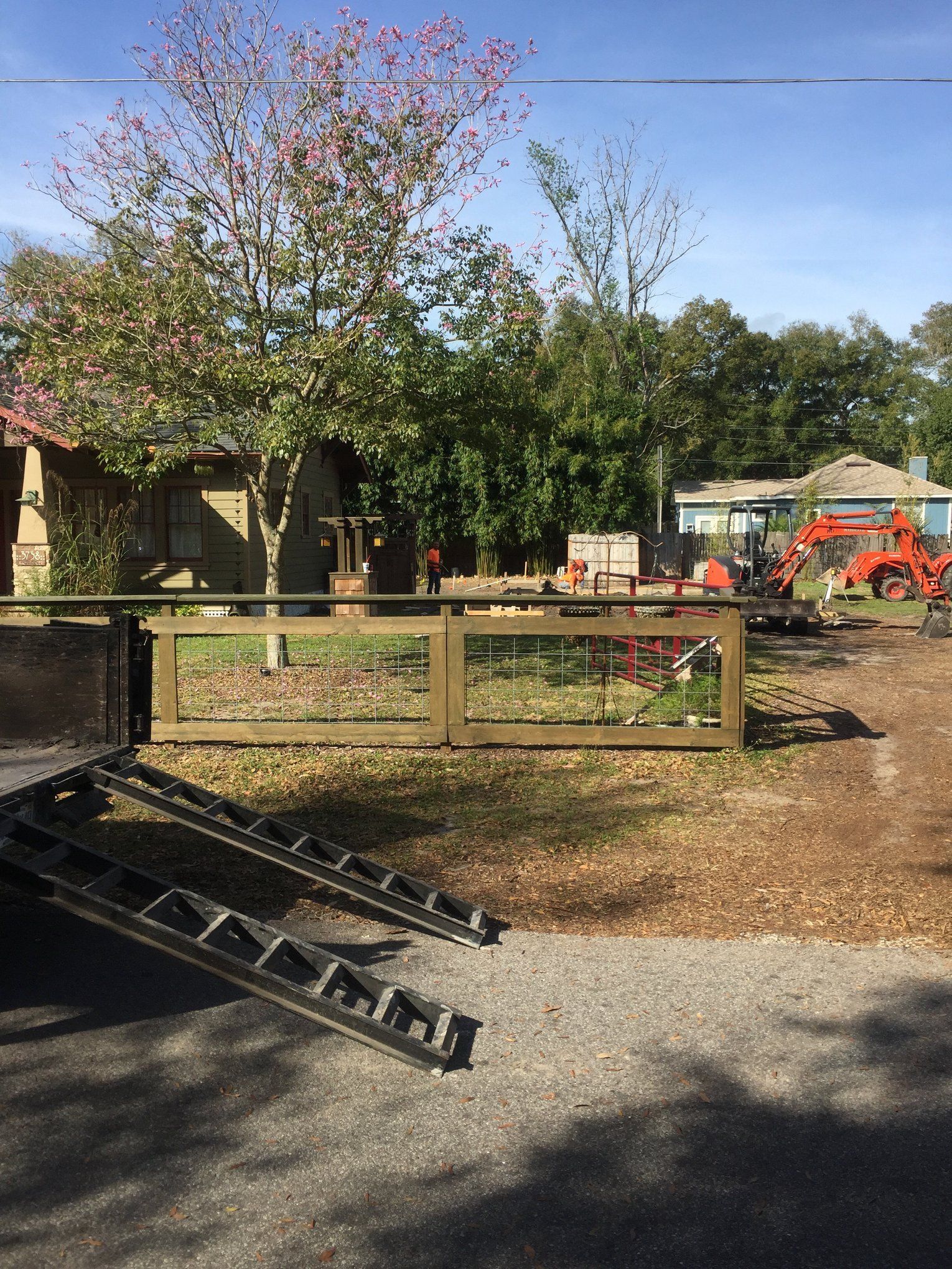 A trailer is parked in a driveway next to a wooden fence.