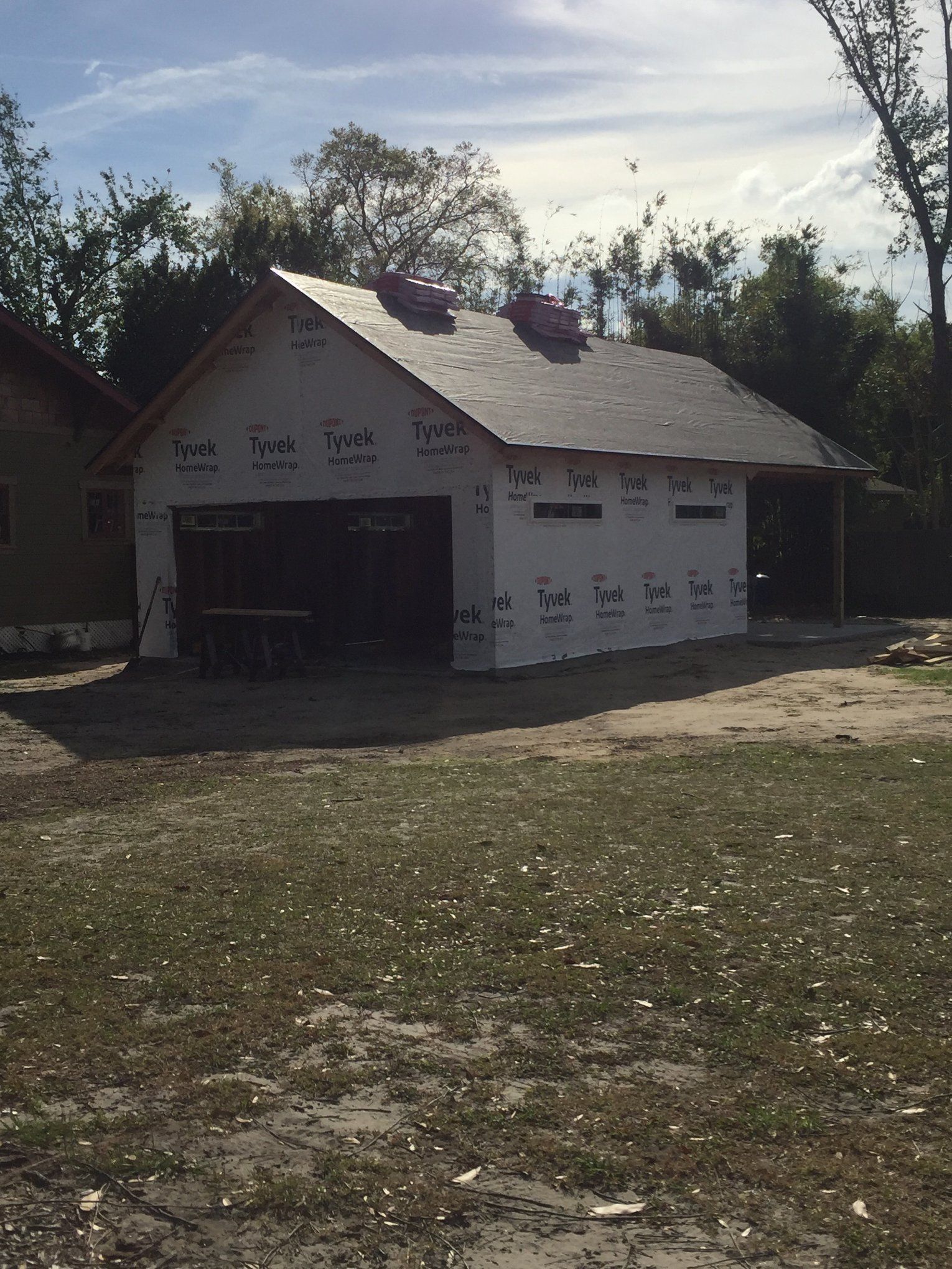 A garage is being built in the middle of a grassy field.
