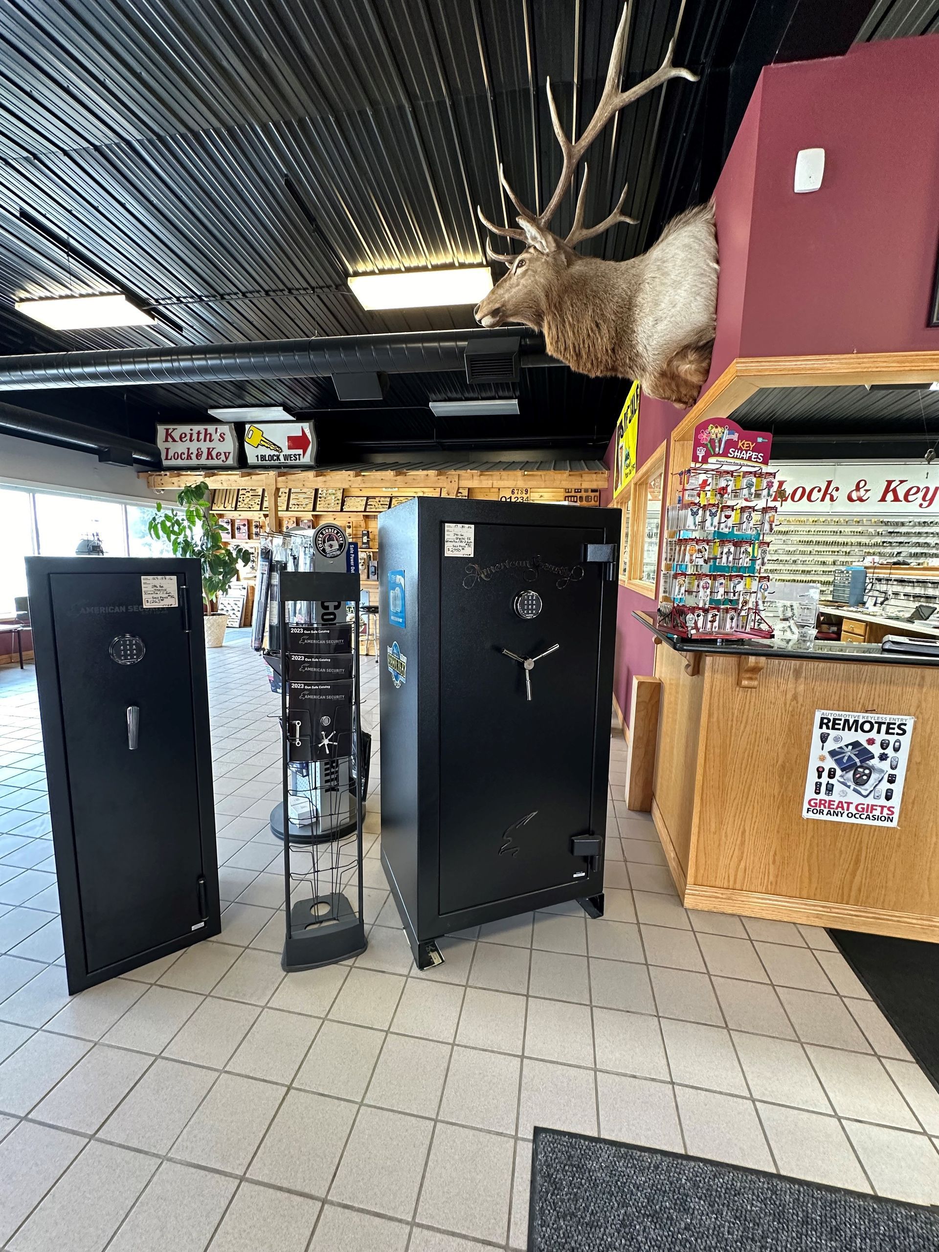 A store filled with lots of safes and a deer head hanging from the ceiling.