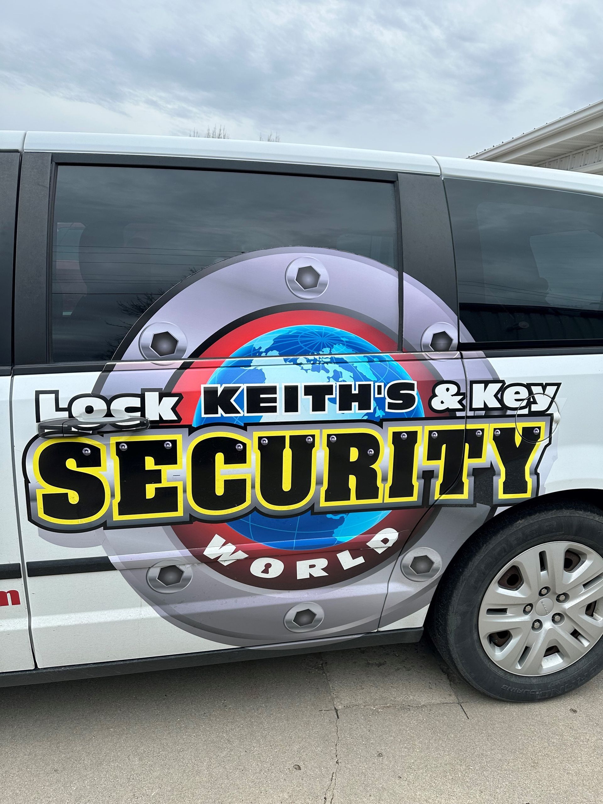 A white van with a sticker on the side that says lock keith 's & key security world
