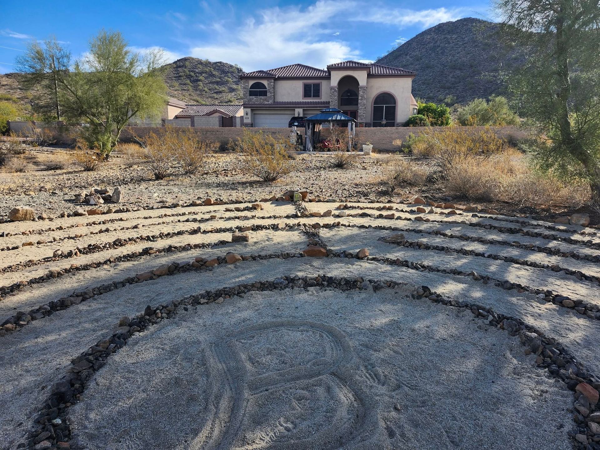 A large house with a labyrinth in front of it