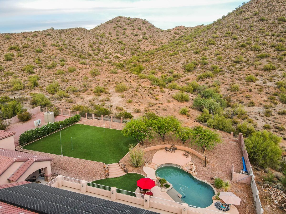An aerial view of a house with a swimming pool in the middle of a desert.