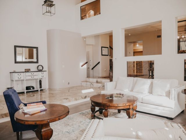 A living room with a couch , chair , table and mirror.