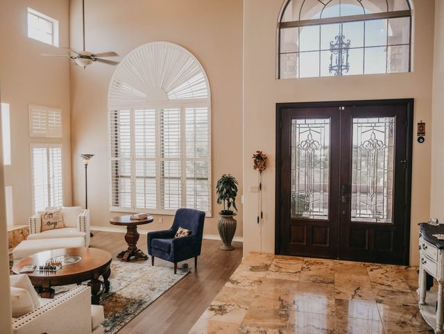A living room with a lot of windows and a ceiling fan.